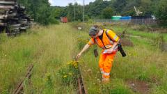 Baneterrænnet ved Lunderskov med mand i orange tøj